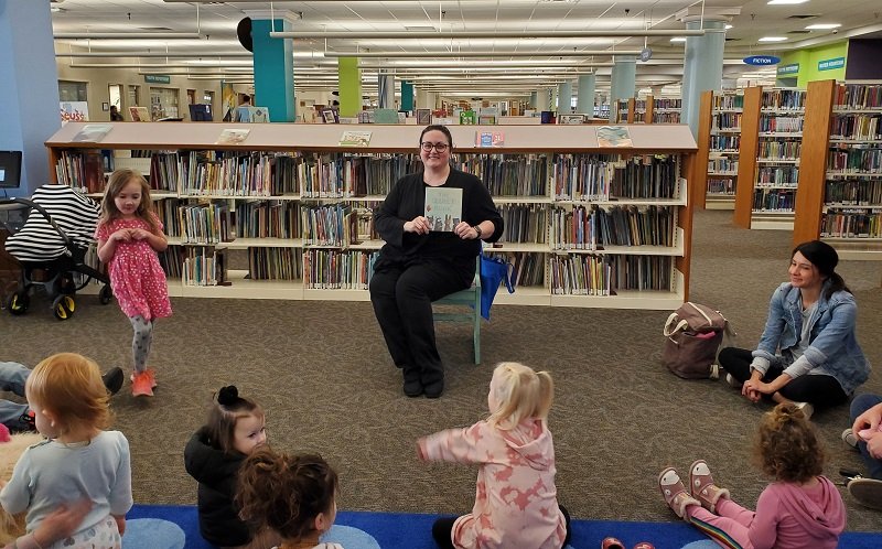Librarian reading the Quiet Book for storytime